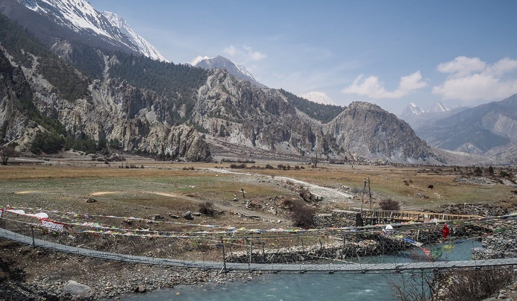 River crossing with suspension bridge in a dry mountain valley
