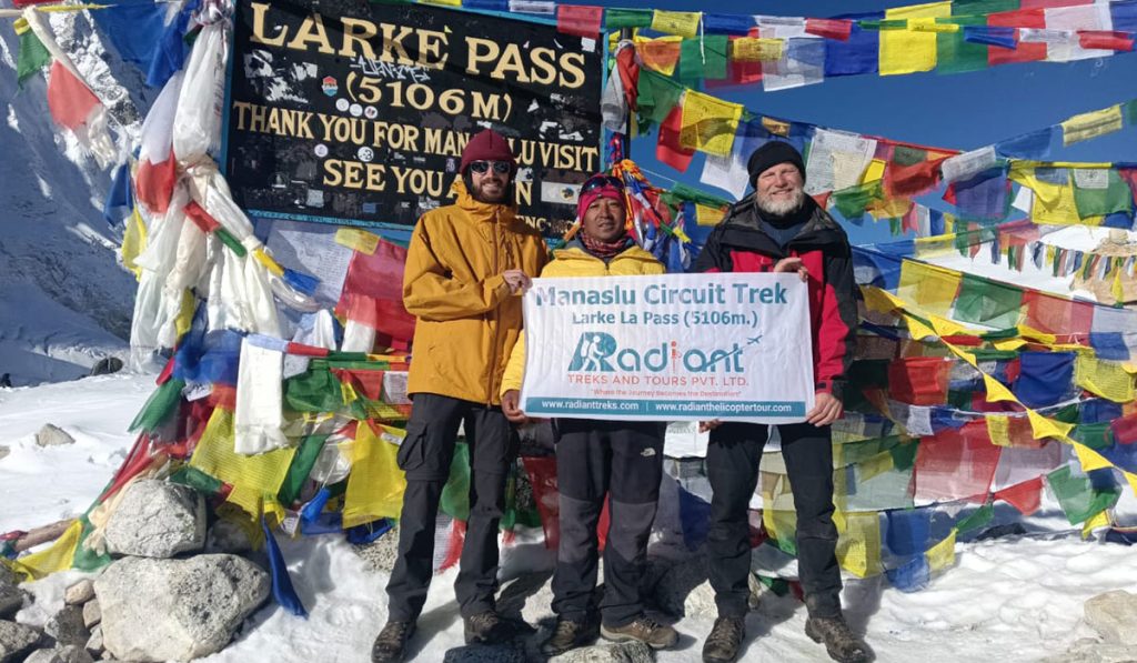 Trekkers at Larke Pass are holding a banner for Radiant Treks.